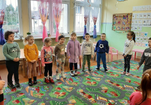 Dzieci z oddziału przedszkolnego i przedszkola w Wartkowicach stoją w kole na sali, uczestniczą w zabawie.
