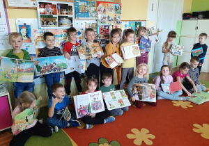 Dzieci pozują do fotografii prezentując swoje ulubione książki z bajkami.