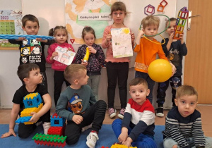 Dzieci prezentują swoje rysunki, ulubione zabawki i przyrządy gimnastyczne