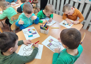 Dzieci kolorują skarpety przy stolikach