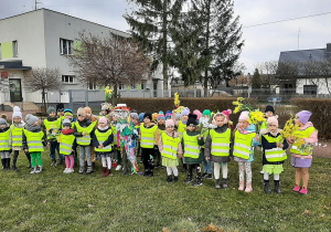 Wszystkie przedszkolaki ustawione do fotografii na placu przedszkolnym. Przedszkolaki maja na sobie kamizelki odblaskowe.