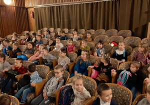 Dzieci siedzą na widowni w sali teatralnej - kolejne ujęcie.