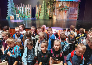 Dzieci z Zespołu Przedszkolnego w Wartkowicach pozują do fotografii na tle sceny teatralnej.
