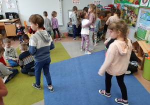Dzieci z placówek bawią się w przedszkolnej sali.