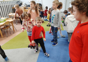 Dzieci z placówek bawią się w przedszkolnej sali - kolejne ujęcie.