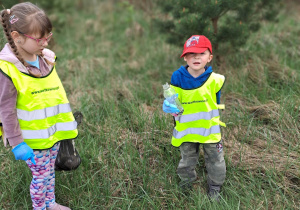 Dzieci z workami sprzątają las