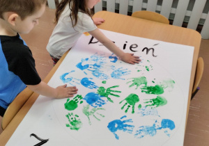 Dzieci z grupy młodszej podczas robienia plakatu