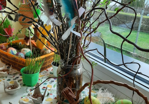 Świąteczno - wiosnenny kącik przyrodniczy na parapecie. Na fotografii widoczne są pisanki, owies, stroiki wielkanocne - kolejne ujęcie.