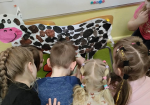 Grupa dzieci przy tekturowej krowie.