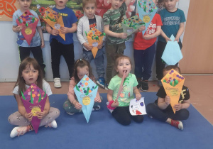 Dzieci w grupie z papierowymi bukietami kwiatów