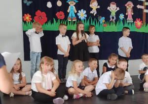 Dzieci 6 letnie na scenie, recytują wiersze wspominając przedszkolne lata.