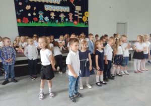 Dzieci z grupy 3,4,5 latków podczas występu. W tle dekoracja.