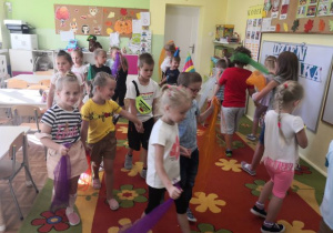 Przedszkolaki podczas tańca w parach trzymające kolorowe apaszki.