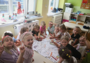 Dzieci kolorują plakat z okazji Dnia Przedszkolaka.