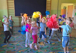Dzieci tańczą z pomponami i chustkami na holu przedszkolnym