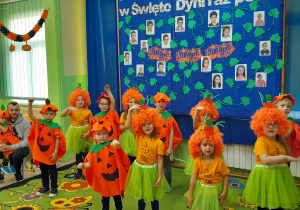 Dzieci w dyniowych kostiumach prezentują jesienny wiersz.