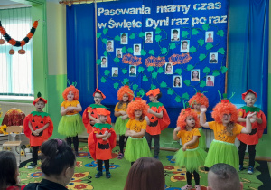 Dzieci w dyniowych kostiumach prezentują piosenkę.