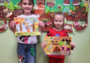 Dziewczynki prezentują jesienne prace na konkurs "Jesień wokół nas".