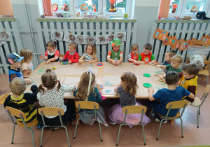 Dzieci przy stolikach z grupy 3-4 latków podczas pracy plastycznej