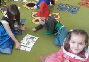 Dzieci w czasie zabawy z kartami przedstawiającymi postaci z bajek