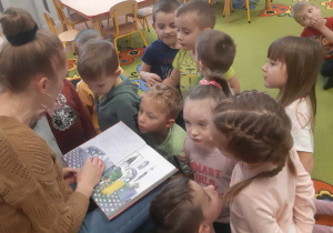 Mama dziecka czyta przedszkolakom książkę