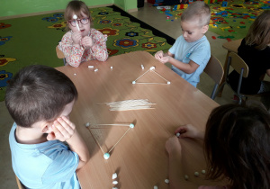 Dzieci podczas zabaw konstrukcyjnych przy stolikach.