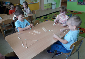 Dzieci podczas zabaw konstrukcyjnych przy stolikach.
