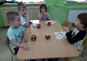 Dzieci prezentują owocowe portrety misia.