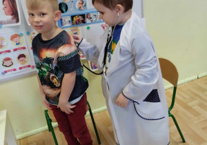 dwoje dzieci z grupy 3,4,5 latków odgrywa scenkę dramową - badanie lekarskie.