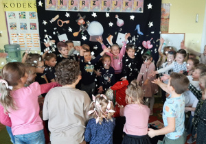 Dzieci stoją w kręgu wypowiadają magiczne zaklęcie, rzucają w górę srebrzysty magiczny pył - konfetti.