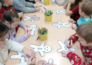 Dzieci w czasie kolorowania papierowych pierników na zajęciach