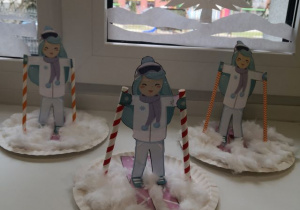 Wystawa prac dzieci przedstawiająca narciarki.