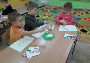 Dzieci przy stolikach układają puzzle pt. "Krasnoludki".