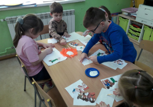 Dzieci przy stolikach układają puzzle pt. "Krasnoludki".
