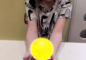 Dziewczynka prezentuje słońce z wykorzystaniem karty 3D.