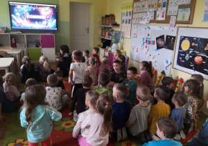 Dzieci oglądają film edukacyjny "Kosmos".