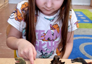 Dziewczynka ogląda karty 3d z dinozaurami
