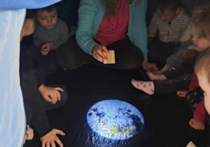 Dzieci w namiocie oglądają Ziemię z rzutnika