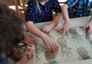 Dzieci przy kolejnym stoliku sprawdzają jak zmieniła się skorupa jajka pod wpływem octu, badają jej "gumową" strukturę.