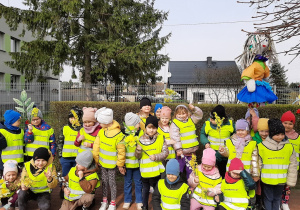 Dzieci z grupy 5,6 latków pozują na placu przedszkolnym trzymając Marzannę.