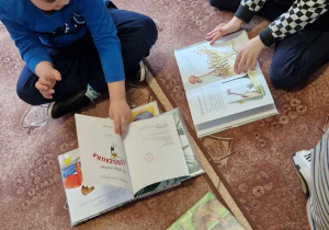 Dzieci przeglądają książki o dinozaurach