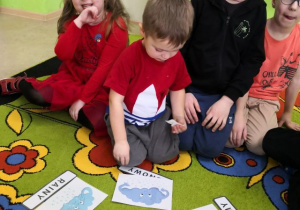 Dzieci podczas zabawy kołowej uczą się zwrotów określających zjawiska pogodowe w języku angielskim.