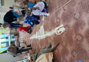 Dzieci kończą układanie szkieletu dinozaura.