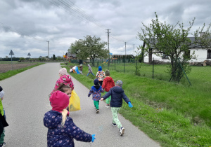 Dzieci porządkują teren wokół przedszkola.