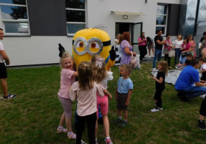 Dziewczynki przytulają się do Minionka i robią zdjęcia pamiątkowe.