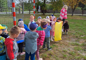 Dzieci idą na pobliski teren przedszkola z workiem na śmieci