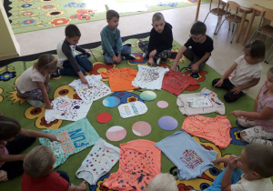 Przedszkolaki prezentują swoje wykropkowane koszulki.