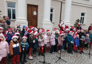 Dzieci stoją przed Pałacem w Starym Gostkowie i śpiewają świąteczne piosenki.