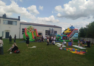 Dzieci z rodzicami korzystają z atrakcji: dmuchane zamki, gry i zabawy sportowe, ogromne bańki podczas Dnia Rodziny na placu OSP w Wartkowicach.