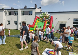 Dzieci z rodzicami korzystają z atrakcji: dmuchane zamki, gry i zabawy sportowe podczas Dnia Rodziny na placu OSP w Wartkowicach.